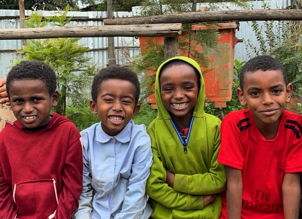 Four boys smiling together in Ethiopia